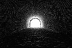 Dunkler Tunnel aus Backsteinen s/w